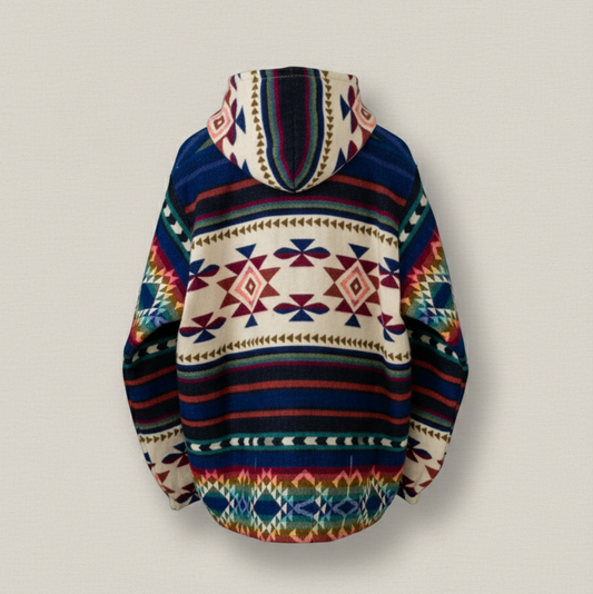 Back view of the ANKA boho jacket made from a wool blend with alpaca, showing colorful geometric Andean patterns in red, blue, green, and cream, photographed against a solid cream background.